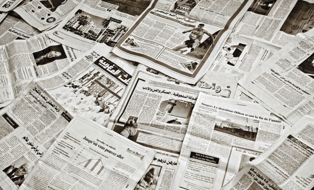 A collection of Arabic newspapers spread across a surface, showcasing diverse headlines and articles.