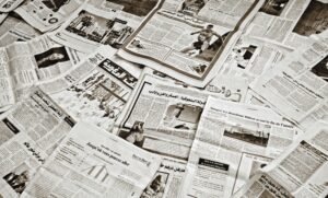 A collection of Arabic newspapers spread across a surface, showcasing diverse headlines and articles.